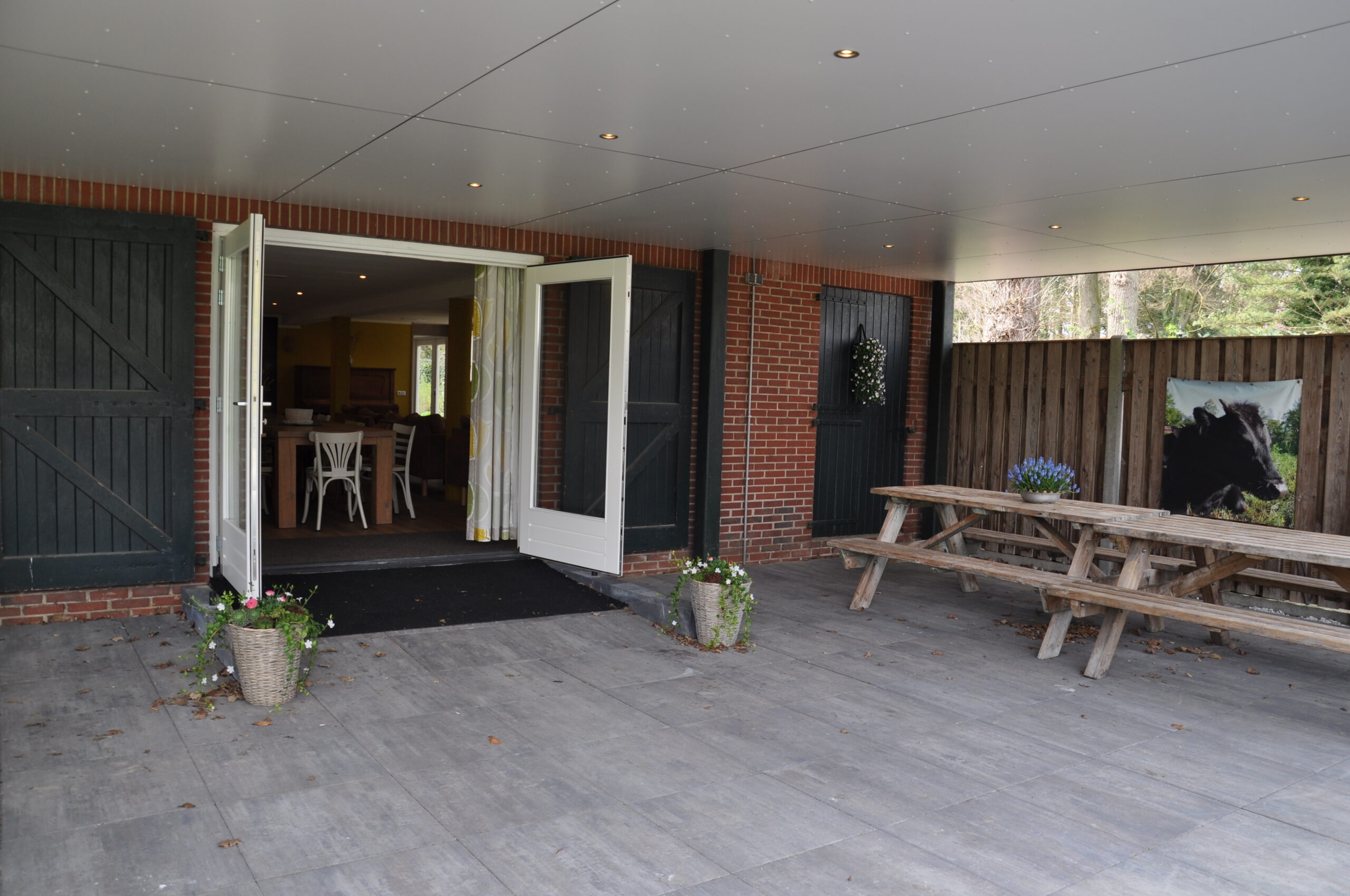 Overdekt terras met zitplaatsen bij Ossenkamp Vakantiehuis